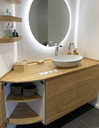 Création d'un meuble de salle de bain en mélaminé blanc et chêne massif, avec une façade courbe.