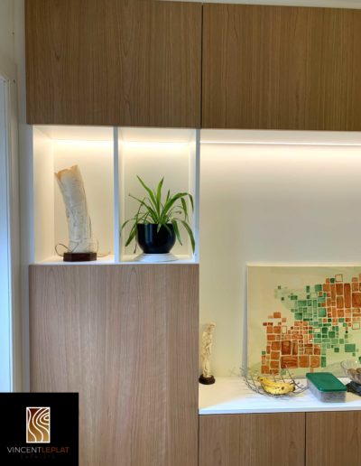Détail sur une niche d'un agencement sur mesure avec éclairage LED et prises intégrées.