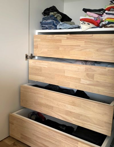 Détail sur des tiroirs dans un dressing. Façades en bois d'hévéa massif.