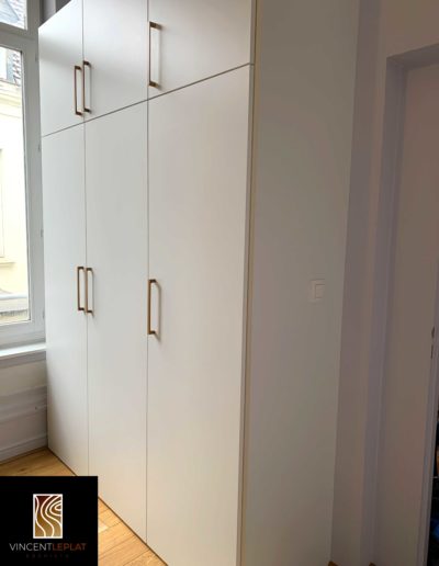 Zoom sur le côté d'une armoire sur mesure bois et blanc.