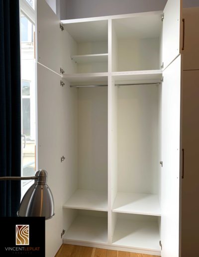 Détail sur la zone penderie d'un dressing blanc et chêne sur mesure